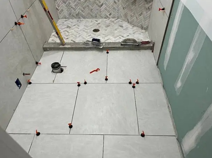 Instalación técnica de pavimentado cerámico con sistemas de nivelación mecánica para asegurar la estanqueidad y evacuación perfecta hacia el desagüe.