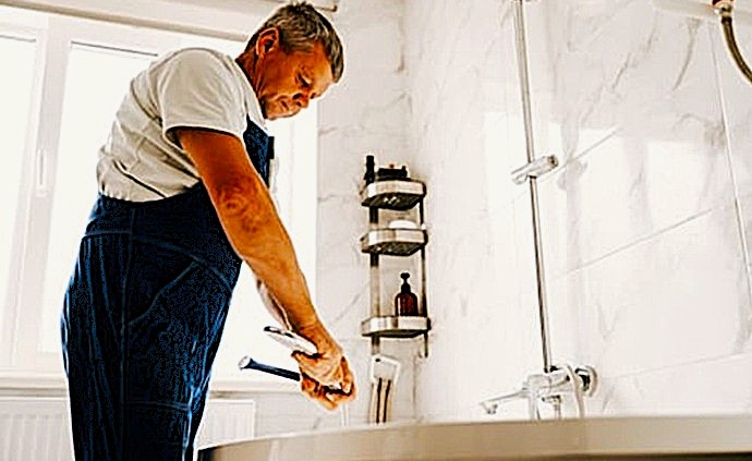Fontanería cualificada ajustando la grifería de bañera mediante herramientas de precisión durante un mantenimiento hídrico en Tenerife Sur.